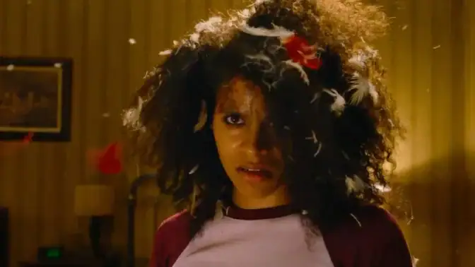 Närbild på en ilsken Zazie Beetz med fjädrar i håret från "They Will Kill You".
