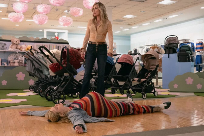 Michelle Pfeiffer står över en gravid Elle Fanning, som ligger raklång på golvet.